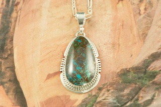Genuine Sunnyside Turquoise set in Sterling Silver Pendant. Created by Navajo Artist Larson Lee. Signed by the artist. The matrix on this rare stone is outstanding. The Sunnyside mine is located in northern Nevada near the town of Tuscarora in the Tuscarora mountain range. Free 18 inch Sterling Silver Chain with purchase of pendant.